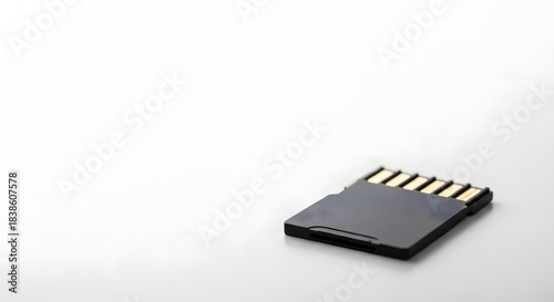 A black micro SD card for digital data storage and electronic devices, prominently displayed on a clean white table for technology concept.