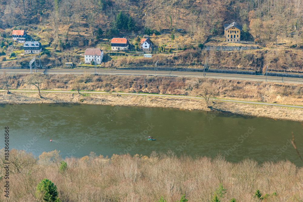 Fototapeta premium Scenic riverside view with houses and railway in serene landscape