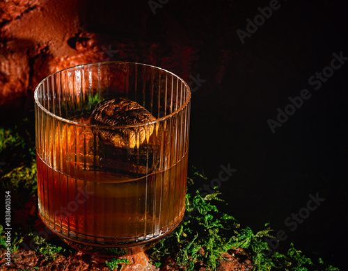 Glass of whisky or bourbon in ornamental glass on dark background.