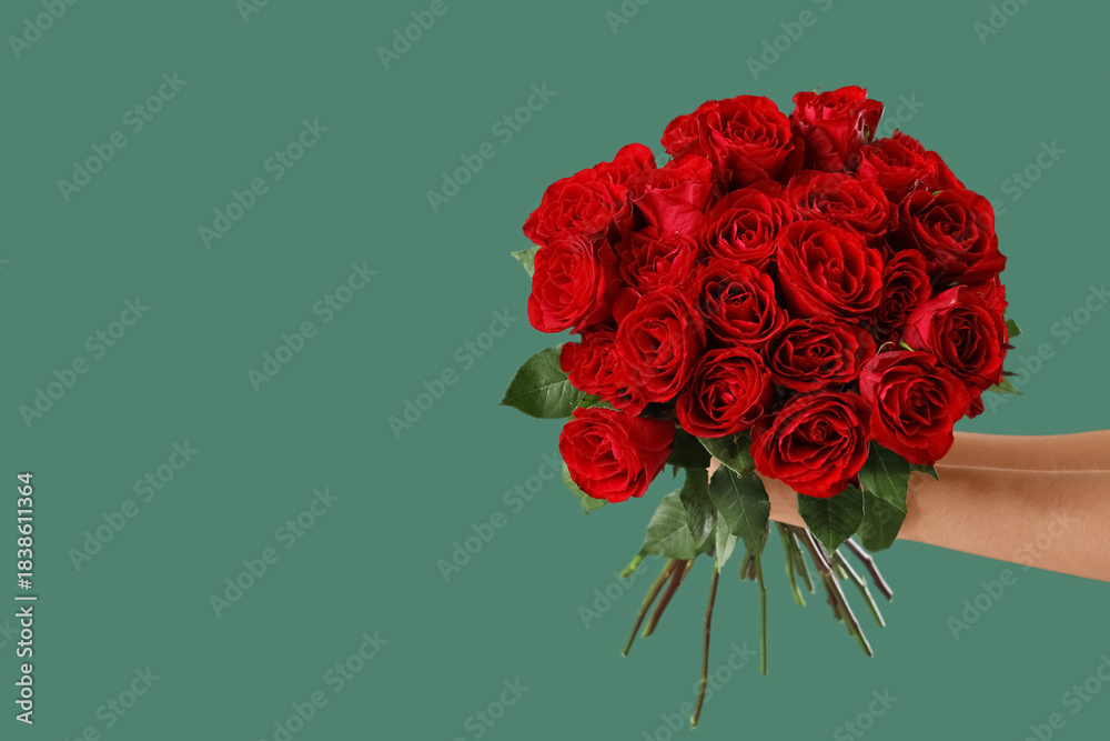 Fototapeta premium Female hands with bouquet of roses on green background. Valentine's Day celebration