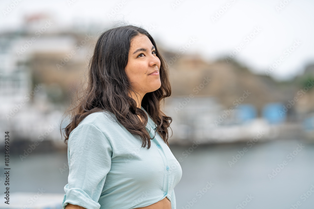 Obraz premium Young woman enjoying a peaceful walk by seaside