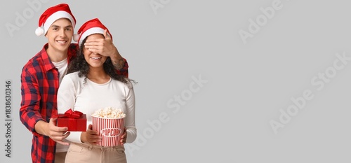 Young couple in Santa hats,...