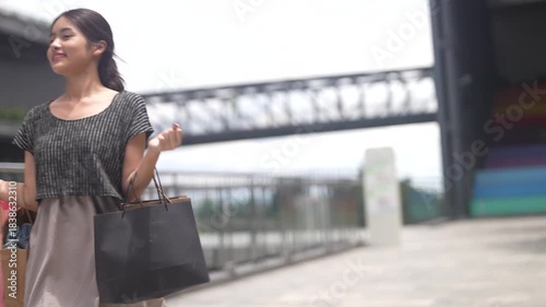 Happy asian woman walking outdoors with shopping bags at mall, joyful shopping fashion, consumer happiness, weekend activity and celebrating purchase, sale promotion, cashback reward after shopping