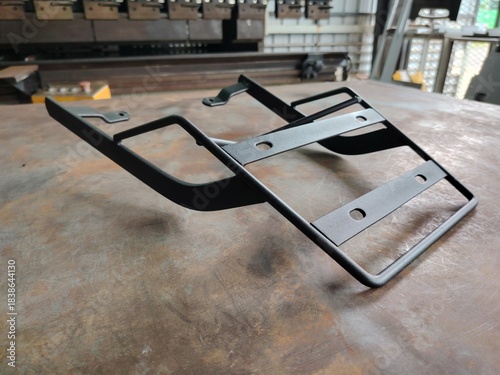 Unused motorcycle luggage carrier sitting on a rustic, distressed metal floor or table surface.