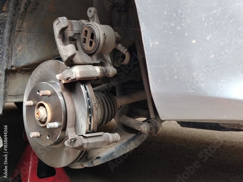 Automotive Upgrade: Shiny New Brake Disc and Axle Ready for Reassembly.