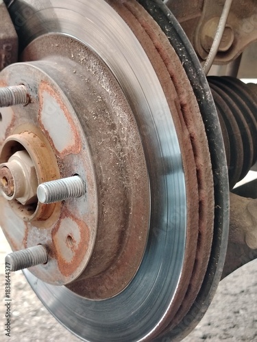 Vehicle Wear and Tear: Rust and Scoring Marks Visible on an Aged Car Brake Rotor.