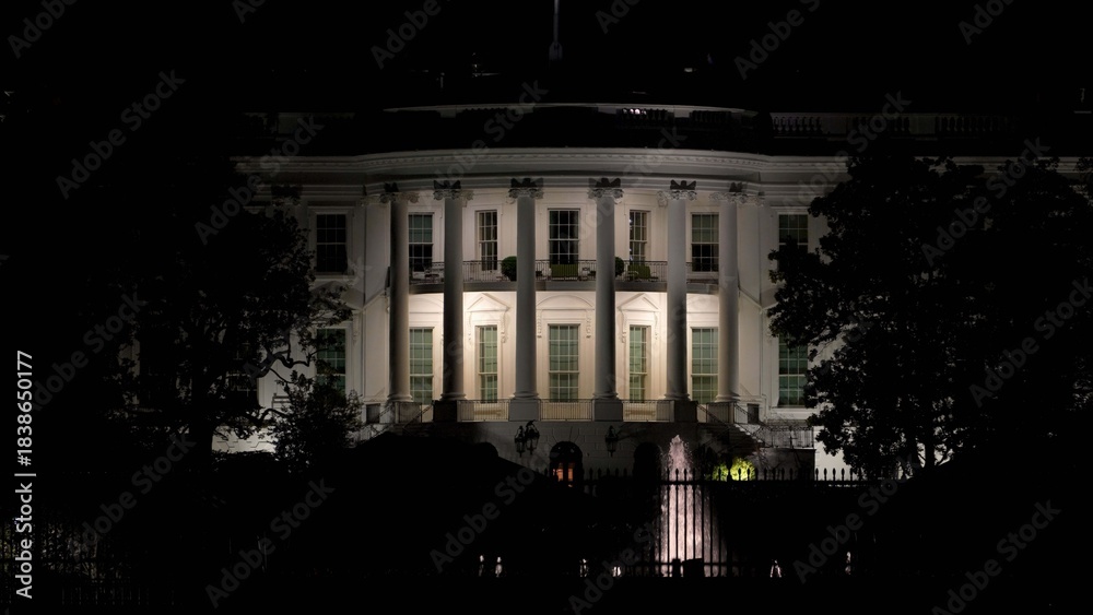 Obraz premium Nighttime view of the Whitehouse with its lights on, showing the buildings features and the dark sky above in Washington DC