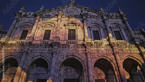 Ornate historic building illuminated by colorful light projections at a nighttime art event