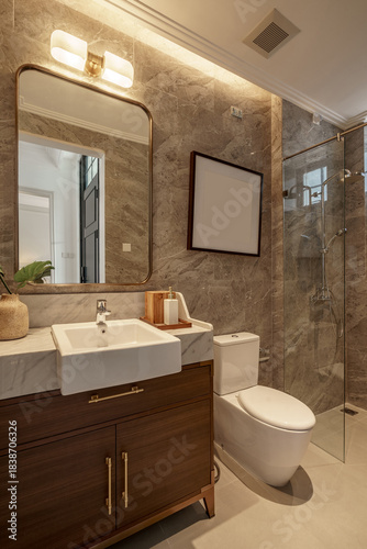 Luxury bathroom interior featuring marble walls, glass shower enclosure, wood vanity, and warm lighting.