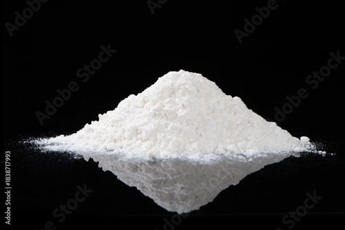 heap of white flour isolated on black background