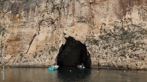 Boat trip in Dwejra begins at a lagoon formed by seawater seeping through a crevice in a cliff on the island of Gozo, Malta