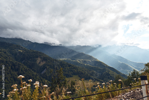 Foto Majestic mountain landscape with rolling hills, a misty valley, and dramatic clo