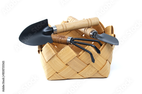 Gardening tools in a woven basket isolated on a white background