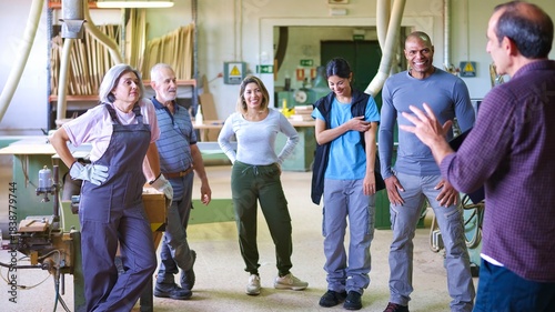 Valokuva Diverse group of workers listening to a supervisor in workshop