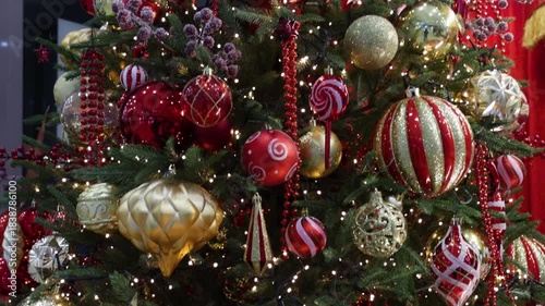The Christmas tree is decorated with glittering ornaments and sparkling lights.