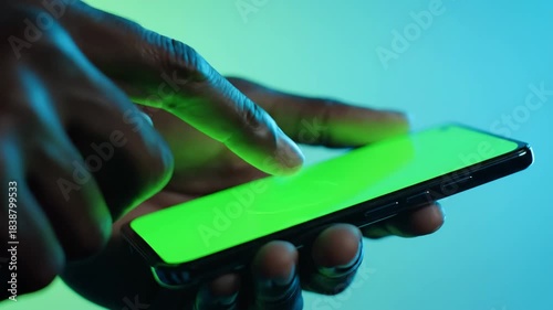 Close-up of a person's hand interacting with a smartphone displaying a green screen