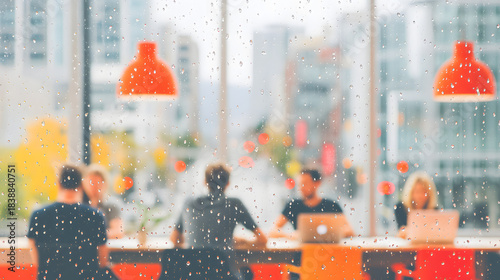 Rain on Window Modern office interior seen through a rain-covered glass window with blurred people working at desks and orange pendant.