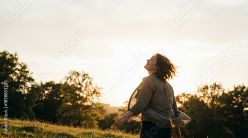 Joyful woman in field at sunset — freedom, gratitude and open sky
