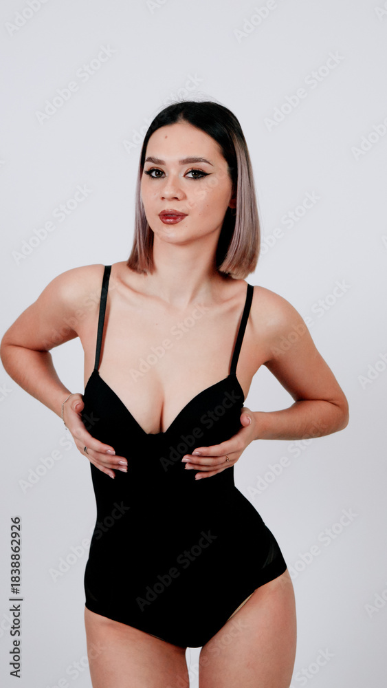 Obraz premium Female model posing in black lace lingerie and high-waisted briefs