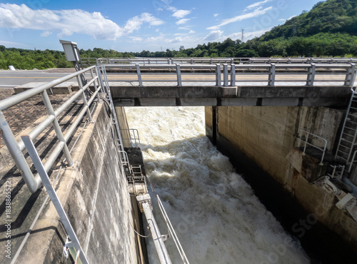 Sluice Gate Releasing Rushing Water Beneath Concrete Bridge.