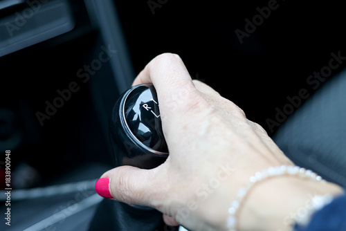 Woman's hand on a car gear shift. Selective focus.