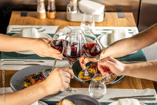 Friends toasting red wine at dinner