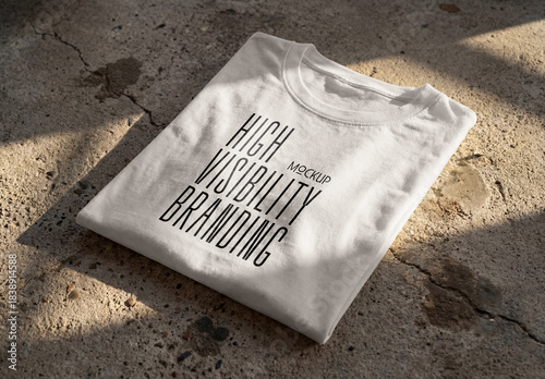 Template Mockup Folded T-Shirt on Concrete Surface with Natural Shadows