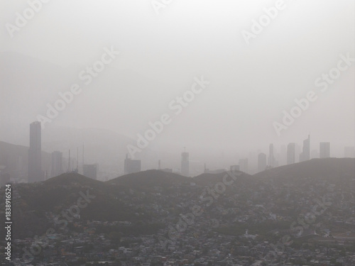Vászonkép City skyline covered in thick smog and pollution near mountains