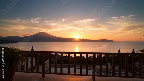 Stunning sunset view from a balcony overlooking the sea with a mountain silhouette
