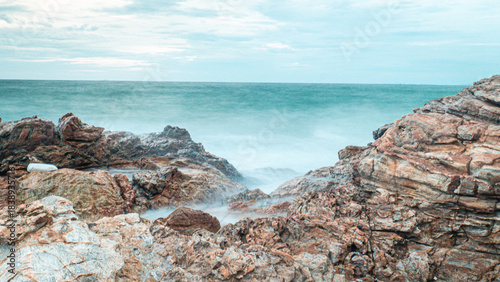 : Serene Long Exposure Waves Crashing on Rugged Rocks Seascape View