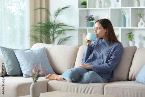 Relaxed woman in blue drinking coffee or tea