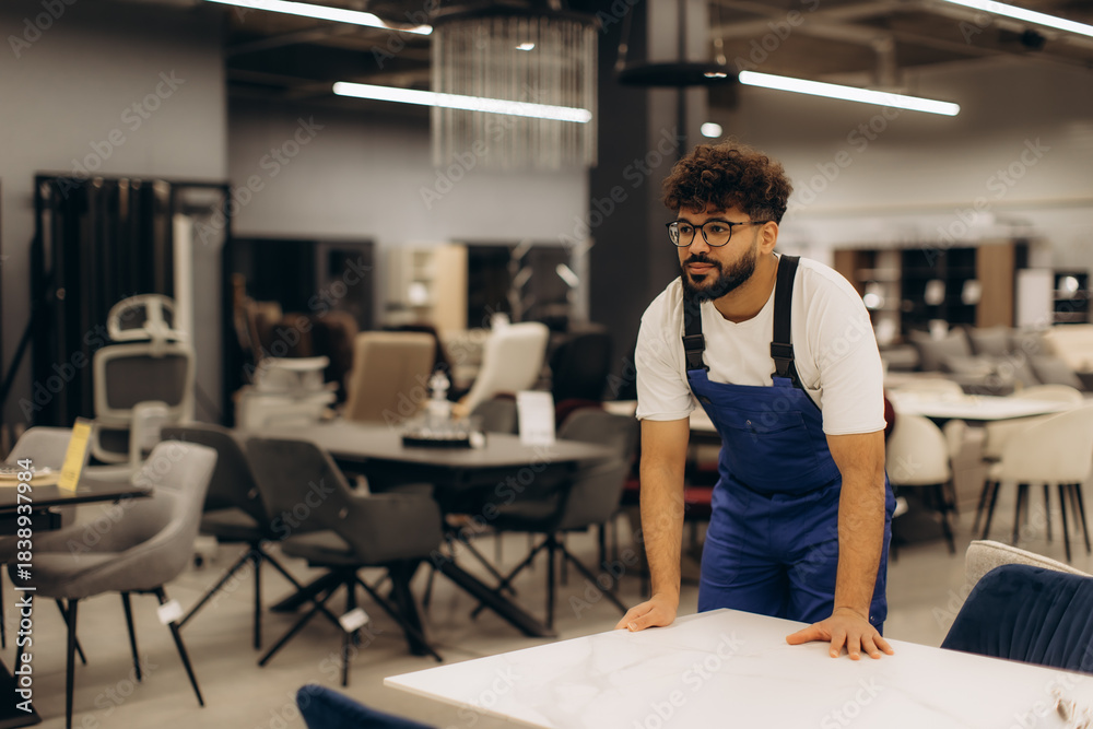 Obraz premium Furniture store worker arranging new table display