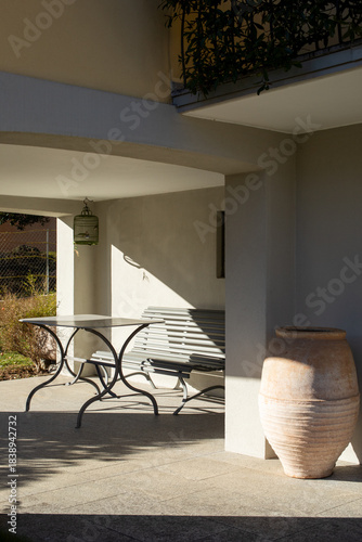 Detail of a typical Swiss porch on a house in Lugano, Ticino. You can see a metal table with a beautiful green wooden bench.
