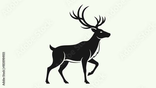 Black silhouette of a regal stag with large antlers walking against a light background