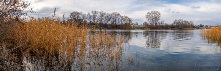 Plexiglas schilderij Reflectie Herfstmeer met riet en dorpshuizen  © Taras