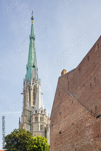 The spire of St. Mary's church in Muhlhausen seen from a back alley
