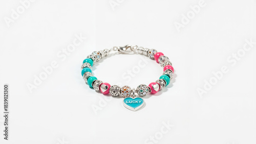 Lucky charm bracelet with colorful beads and heart pendant on a light background