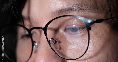 Man smartphone user with eyeglasses news through social media reels in dark room, Closeup of eyes.
