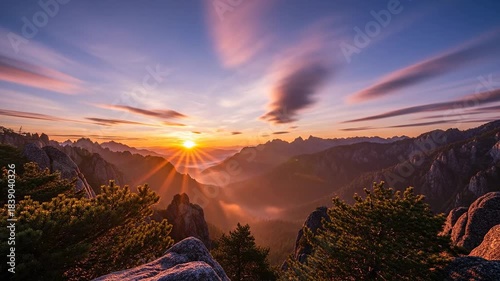 Majestic Sunrise Over Misty Mountains with Streaking Clouds.