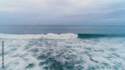 柔らかな雲に覆われた空の下で、穏やかな海の波が一定のリズムで寄せては返します。
淡いブルーとグレーを基調とした色合いが、深い安心感と静寂を生み出します