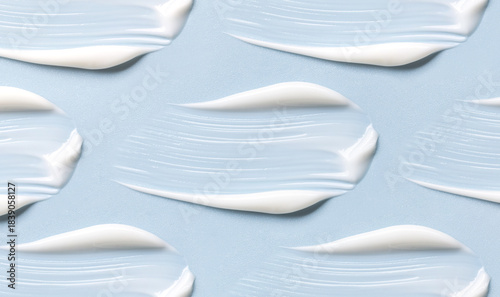 pattern of cream smears of creamy texture on blue background