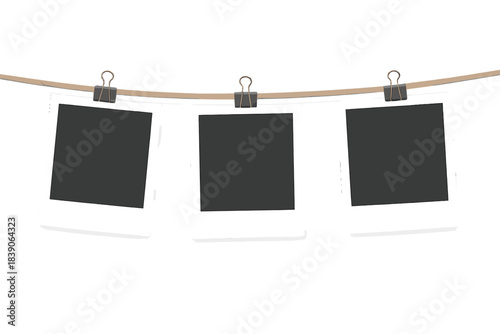 Three blank instant film prints hanging on a rope with clips