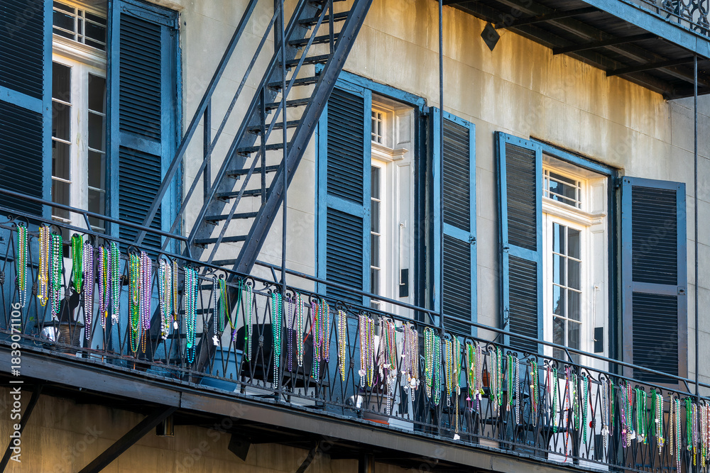 Fototapeta premium Mardi Gras beads on a balcony on a building in a street of the French Quarter, New Orleans architecture, Louisiana