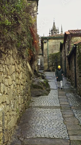 Person Walking in Narrow Historic Stone Alley