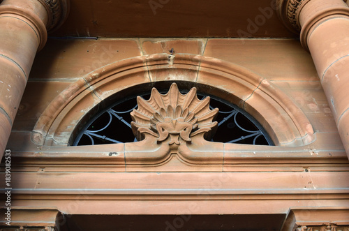 Carved Stone Arched Window Above Door Between Circular Pillars 