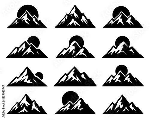 Silhouettes of mountain peaks with sun positioned behind them. Each mountain shows unique ridge patterns and snow accents