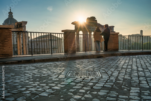 Couple visit Temple of Saturn at Roman forum ruins onsunrise in Rome. Italy