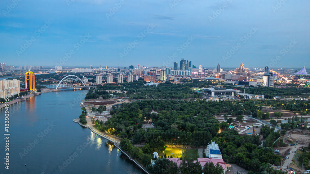 Fototapeta premium Elevated view over the city center with river and park and central business district day to night Timelapse, Kazakhstan, Astana