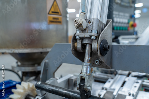Pneumatic cylinder and linkage mechanism in industrial machine, close-up
