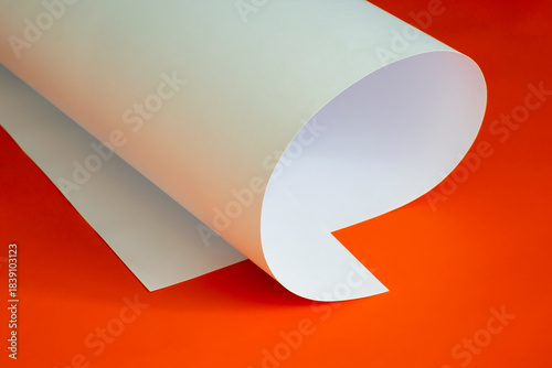 A sheet of thin cardboard on a red background.